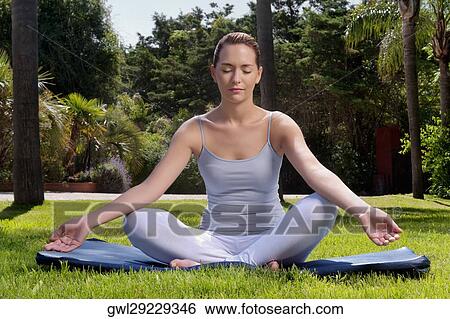 Woman practicing yoga in a park View Large Photo Image Stock Photograph - Woman practicing yoga in a park. Fotosearch