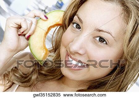 Woman pretending to hold a telephone receiver with a melon slice View Large Photo Image Stock Photography - Woman pretending to hold a telephone receiver with a melon slice. Fotosearch