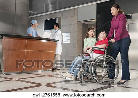 Stock Photo - Woman pushing her son in a wheelchair. Fotosearch