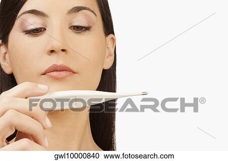 Stock Image - Woman reading a thermometer. Fotosearch