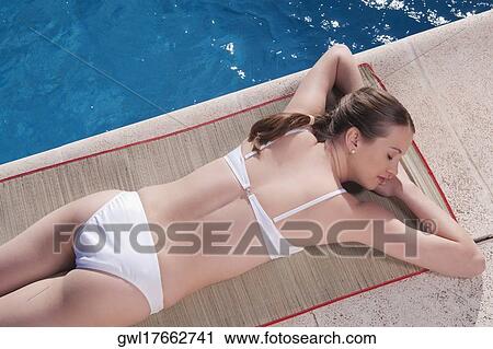 Woman resting by a swimming pool View Large Photo Image Stock Image - Woman resting by a swimming pool. Fotosearch