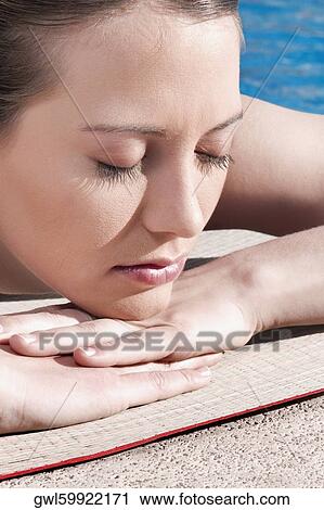 Woman resting by a swimming pool View Large Photo Image Stock Image - Woman resting by a swimming pool. Fotosearch