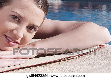 Woman resting by a swimming pool View Large Photo Image Stock Photograph - Woman resting by a swimming pool. Fotosearch