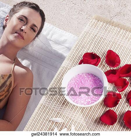 Woman resting with aroma products beside her at the poolside View Large Photo Image Picture - Woman resting with aroma products beside her at the poolside. Fotosearch