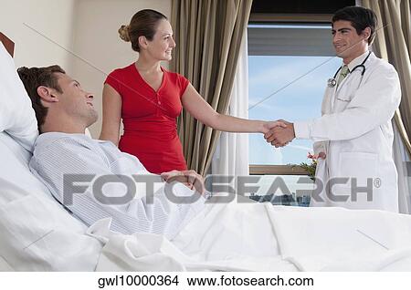 Woman shaking hand with a doctor View Large Photo Image Picture - Woman shaking hand with a doctor. Fotosearch