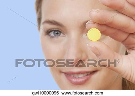 Woman showing a pill View Large Photo Image Stock Photograph - Woman showing a pill. Fotosearch