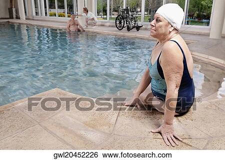 Woman sitting at the poolside View Large Photo Image Stock Photograph - Woman sitting at the poolside. Fotosearch