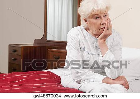 Woman sitting on the bed and thinking View Large Photo Image Picture - Woman sitting on the bed and thinking. Fotosearch