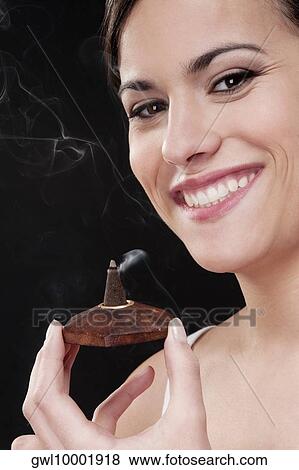 Woman smelling a burning incense cone View Large Photo Image Stock Photo - Woman smelling a burning incense cone. Fotosearch