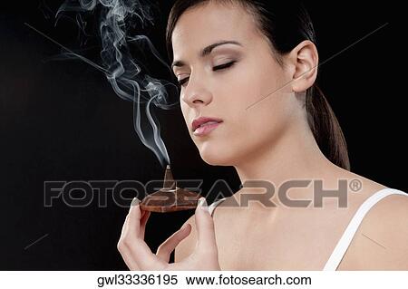 Woman smelling a burning incense cone View Large Photo Image Stock Photography - Woman smelling a burning incense cone. Fotosearch