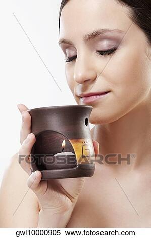 Woman smelling an incense burner View Large Photo Image Stock Photography - Woman smelling an incense burner. Fotosearch