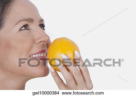 Woman smelling an orange View Large Photo Image Picture - Woman smelling an orange. Fotosearch