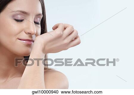 Woman smelling aromatherapy oil on her wrist View Large Photo Image Stock Image - Woman smelling aromatherapy oil on her wrist. Fotosearch