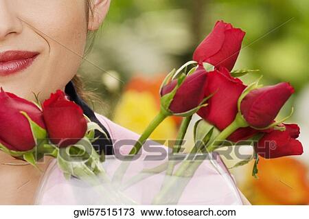 Woman smelling flowers in a greenhouse View Large Photo Image Stock Image - Woman smelling flowers in a greenhouse. Fotosearch