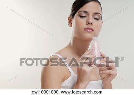 Stock Image - Woman smelling moisturizer cream. Fotosearch