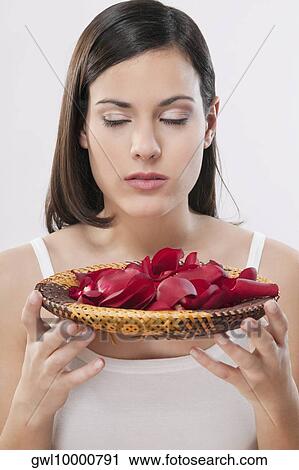Stock Image - Woman smelling rose petals. Fotosearch