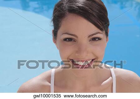 Woman smiling with a swimming pool in the background View Large Photo Image Stock Photography - Woman smiling with a swimming pool in the background. Fotosearch