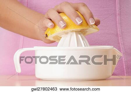 Woman squeezing orange with juicer View Large Photo Image Stock Image - Woman squeezing orange with juicer. Fotosearch