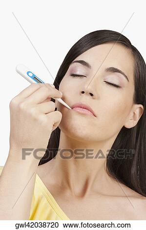 Woman taking her temperature View Large Photo Image Stock Image - Woman taking her temperature. Fotosearch