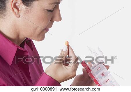 Woman taking medicine from a pill box View Large Photo Image Stock Image - Woman taking medicine from a pill box. Fotosearch