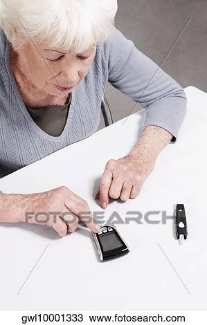 Woman testing her blood sugar level View Large Photo Image Stock Image - Woman testing her blood sugar level. Fotosearch