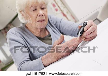 Woman testing her blood sugar level View Large Photo Image Stock Image - Woman testing her blood sugar level. Fotosearch