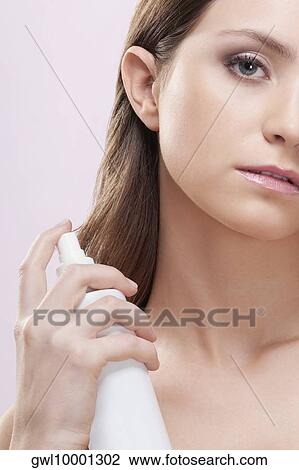 Woman using a spray can deodorant View Large Photo Image Stock Image - Woman using a spray can deodorant. Fotosearch