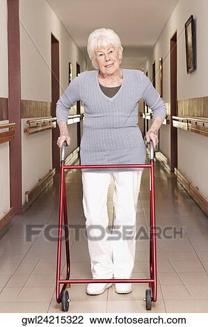 Woman walking with the help of a walker View Large Photo Image Stock Image - Woman walking with the help of a walker. Fotosearch