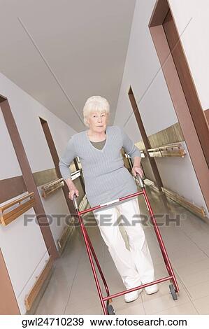 Stock Photo - Woman walking with the help of a walker. Fotosearch