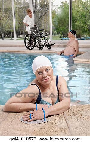 Woman wearing swim paddles in a swimming pool View Large Photo Image Stock Photo - Woman wearing swim paddles in a swimming pool. Fotosearch