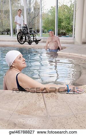 Woman wearing swim paddles in a swimming pool View Large Photo Image Stock Photo - Woman wearing swim paddles in a swimming pool. Fotosearch