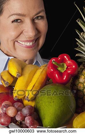 Woman with assorted fruits View Large Photo Image Stock Image - Woman with assorted fruits. Fotosearch
