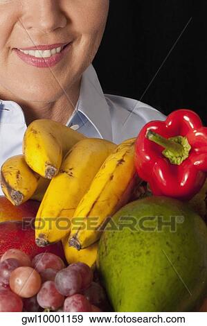 Woman with assorted fruits View Large Photo Image Stock Photo - Woman with assorted fruits. Fotosearch