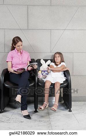 Stock Photo - Woman with her daughter in a hospital waiting room. Fotosearch