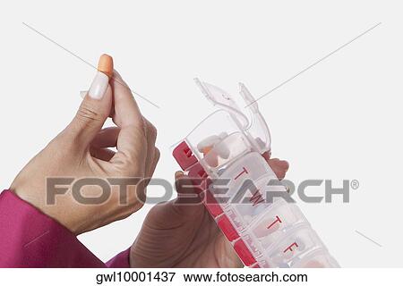 Woman's hand taking pill from a week pill box View Large Photo Image Stock Photo - Woman's hand taking pill from a week pill box. Fotosearch