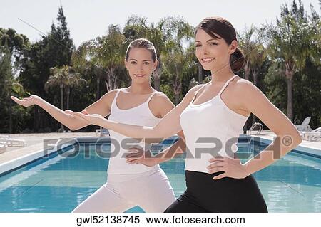Stock Photography - Women exercising at the poolside. Fotosearch
