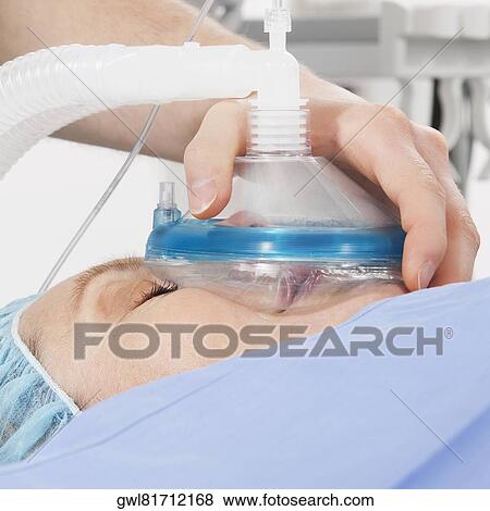 Anesthetist holding oxygen mask over patient's mouth in hospital View Large Photo Image Stock Photo - Anesthetist holding oxygen mask over patient's mouth in hospital. Fotosearch