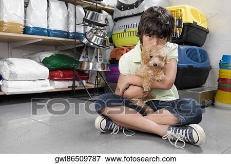 Boy carrying a puppy in a supermarket View Large Photo Image Stock Photo - Boy carrying a puppy in a supermarket. Fotosearch