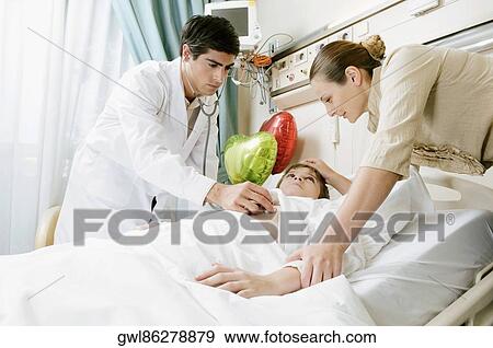 Boy on a hospital bed being examined by a doctor View Large Photo Image Stock Photo - Boy on a hospital bed being examined by a doctor. Fotosearch