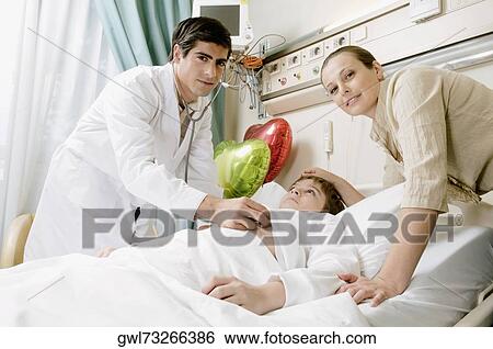 Stock Photograph - Boy on a hospital bed being examined by a doctor. Fotosearch