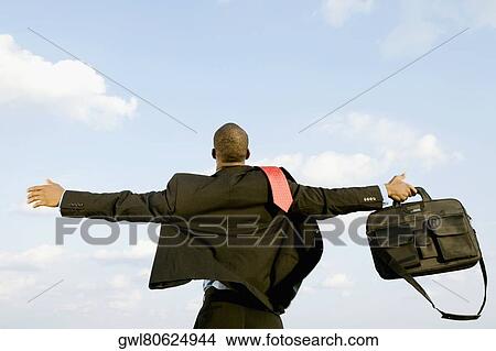 Businessman standing with his arm outstretched View Large Photo Image Picture - Businessman standing with his arm outstretched. Fotosearch