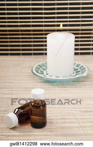 Candle with aromatherapy oil bottles View Large Photo Image Stock Photo - Candle with aromatherapy oil bottles. Fotosearch