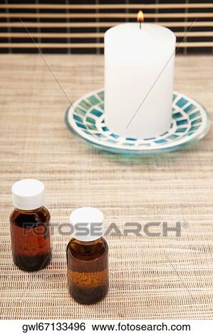 Candle with aromatherapy oil bottles View Large Photo Image Stock Photograph - Candle with aromatherapy oil bottles. Fotosearch