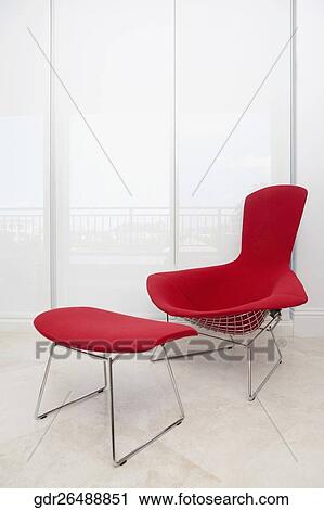 Stock Image - Chair with a footstool in a domestic room. Fotosearch