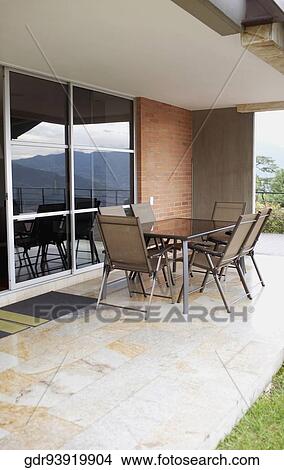 Chairs in the porch in front of a house View Large Photo Image Picture - Chairs in the porch in front of a house. Fotosearch