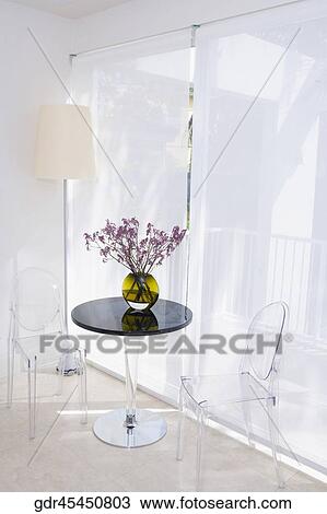 Chairs with a flower pot on a table in the living room View Large Photo Image Stock Image - Chairs with a flower pot on a table in the living room. Fotosearch