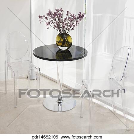 Chairs with a flower pot on a table in the living room View Large Photo Image Stock Photography - Chairs with a flower pot on a table in the living room. Fotosearch