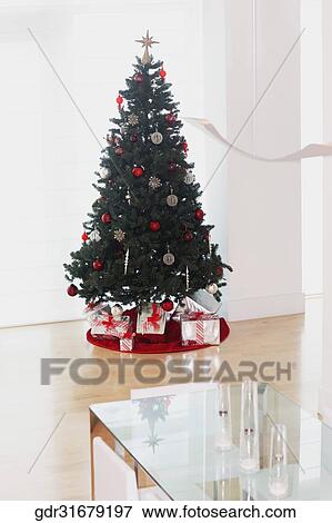 Christmas tree with gifts in a room View Large Photo Image Stock Photo - Christmas tree with gifts in a room. Fotosearch