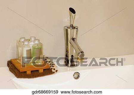 Close-up of a bathroom sink with toiletries View Large Photo Image Stock Photo - Close-up of a bathroom sink with toiletries. Fotosearch