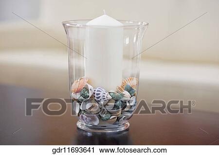 Close-up of a candle with shells in a vase View Large Photo Image Stock Image - Close-up of a candle with shells in a vase. Fotosearch